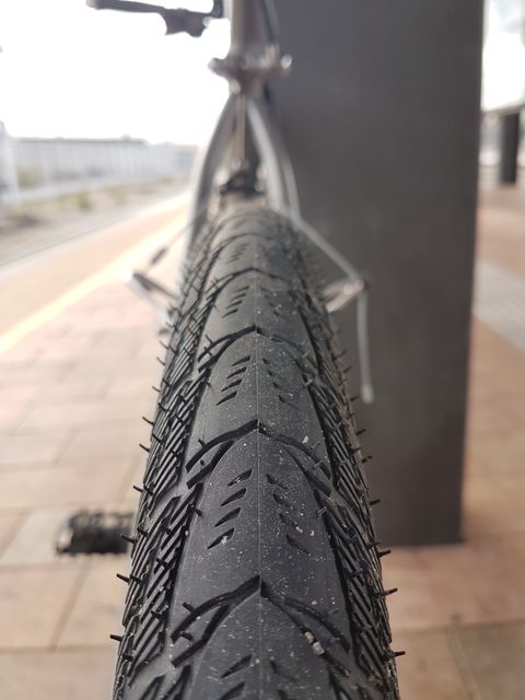 Close-up Focus on Bicycle Tire with Urban Background - Download Free Stock Images Pikwizard.com