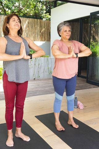 Diverse women practicing yoga on peaceful outdoor patio