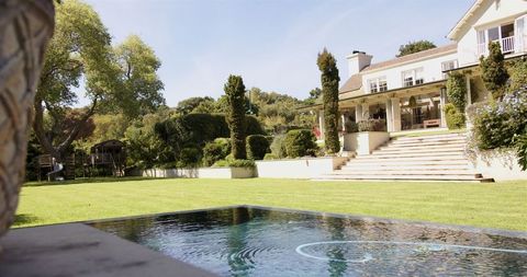 Luxurious Mansion with Expansive Garden and Pool on Sunny Day