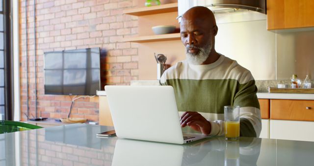 Senior Man Working on Laptop in Modern Kitchen - Download Free Stock Images Pikwizard.com