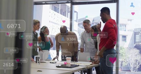 Cross-functional team collaborating at table reviewing marketing plans with social overlays