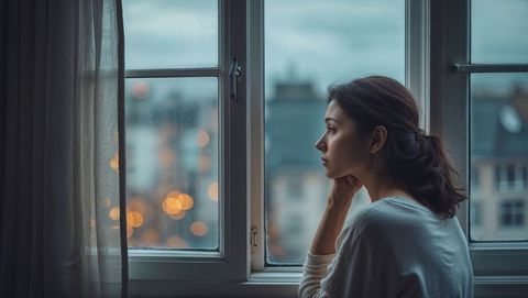 Contemplating Woman by Raindrop-Flecked Urban Window