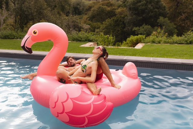 Couple sleeping together on a inflatable tube in swimming pool in the backyard
