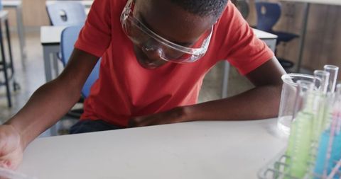 Young student exploring science lab with safety goggles
