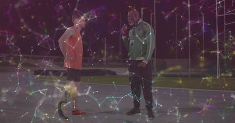 Coach Interviews Athlete with Prosthetic on Night Track