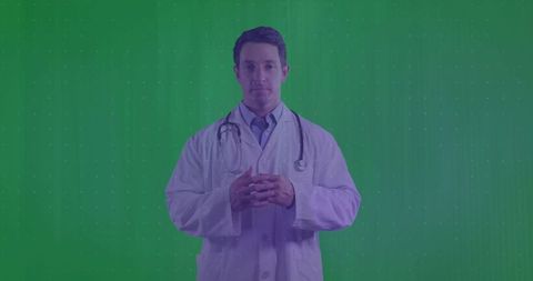 Standing doctor in white lab coat with stethoscope on green chroma background for medical media