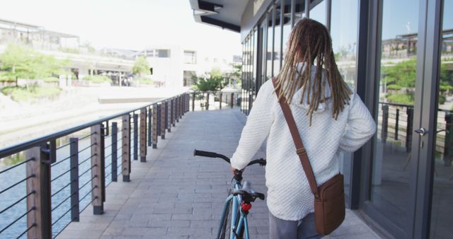 Urban Commuter Walking Bicycle by Riverfront Building - Download Free Stock Images Pikwizard.com