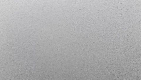 Light gray plaster texture featuring fine speckle and soft tonal gradient, closeup