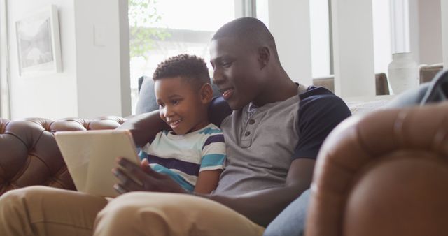 Happy Father and Son Using Tablet on Couch at Home - Download Free Stock Images Pikwizard.com