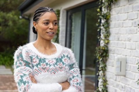 Confident african american woman standing outdoors in cozy fuzzy sweater, arms crossed