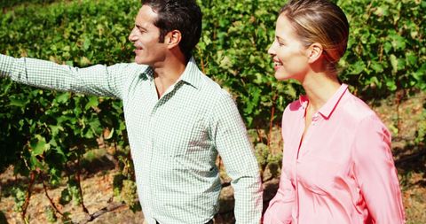 Cheerful Couple Strolling Through Green Vineyard