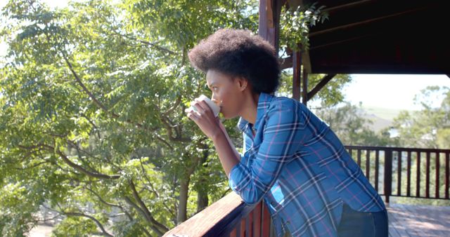 Woman Enjoying Morning Coffee on Balcony Surrounded by Green Trees - Download Free Stock Images Pikwizard.com