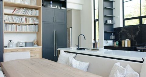 Sunlit Minimalist Open-Plan Kitchen with Wooden Dining Table and White Island