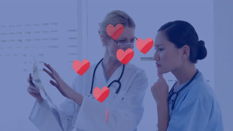 Heart Icons Floating Over Doctors Analyzing Radiology Scan
