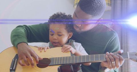 Father Teaching Son Acoustic Guitar at Home