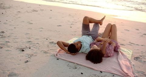 Relaxed Couple Lying on Beach at Sunset