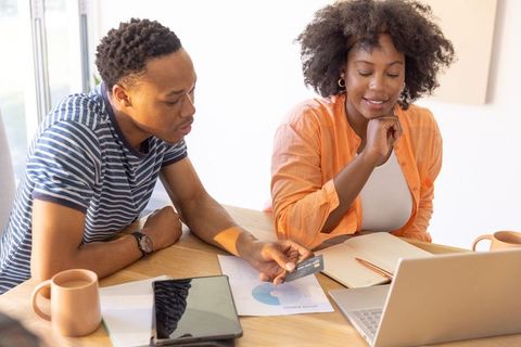 African american couple planning budget and checking online banking with credit card