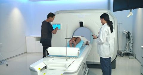Medical team preparing patient for ct scan in radiology suite with advanced imaging