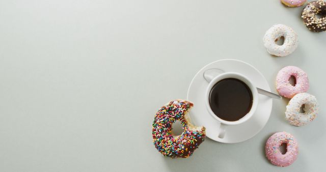 Ideal for websites or blogs featuring breakfast ideas, food photography, cafes, or sweets. The colorful donuts add a playful touch, making it suitable for use in posters, print advertisements, or social media posts promoting coffee shops or bakeries.