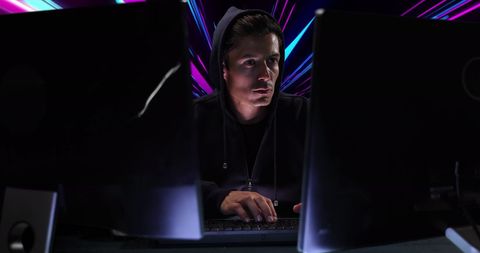 Focused Hacker Engaging in Cybersecurity with Neon Background - Download Free Stock Images Pikwizard.com