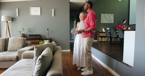 Happy Interracial Couple Embracing at Home Celebration