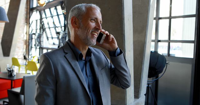 Smiling Businessman CoWorking Space Making Phone Call Wearing Grey Suit - Download Free Stock Images Pikwizard.com