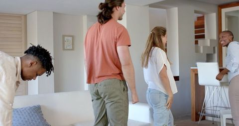 Friends Socializing and Laughing Together in Modern Living Room