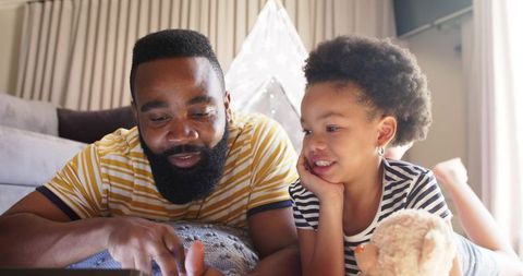 Father and Daughter Enjoying Time with Tablet in Cozy Living Room