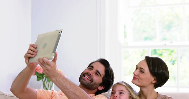 Happy Family Relaxing on Sofa with Tablet at Home - Download Free Stock Images Pikwizard.com