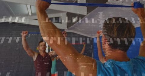 Instructor leading group stretch with elastic bands in fitness studio