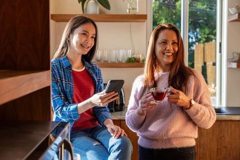 Mother and Daughter Bonding in Home Kitchen Enjoying Tea