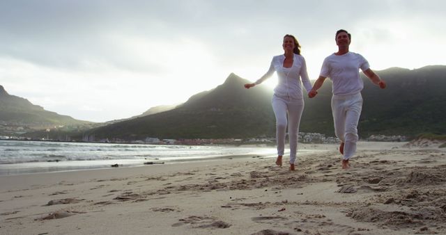 Happy Couple Running on Scenic Beach at Sunset - Download Free Stock Images Pikwizard.com