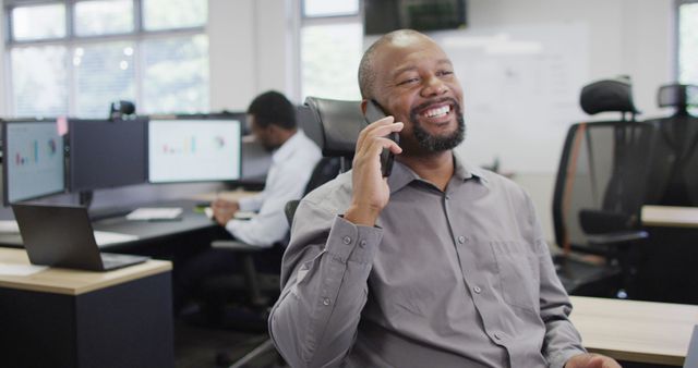 Smiling Man Talking on Phone in Modern Office Environment - Download Free Stock Images Pikwizard.com