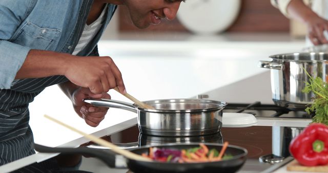 Young Man Cooking With Enthusiasm in Modern Kitchen - Download Free Stock Images Pikwizard.com