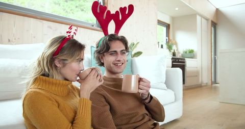 Festive Antler Headbands, Friends Sharing Cozy Drinks in Modern Room