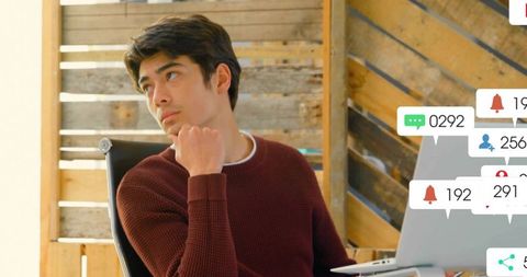 Young professional contemplating at modern desk with notifications