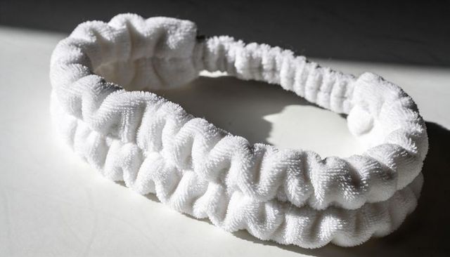 White terry cloth headband with ruched texture and elastic comfort for skincare routine