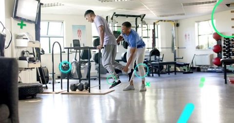 Personal trainer guiding single-leg balance on parallel dip bars for strength