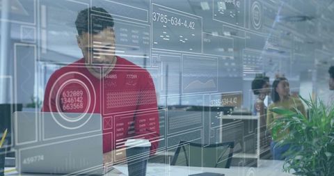 Businessman in Red Sweater Working on Laptop in Modern Office