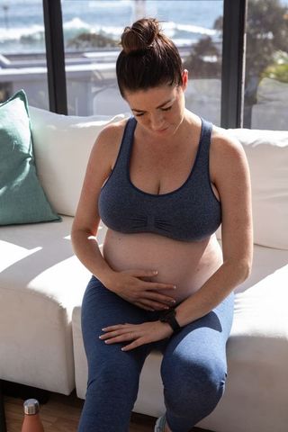 Pregnant Woman Relaxing on Sofa with Natural Light