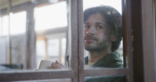 Man Looking Out Window with Coffee in Cozy Space - Download Free Stock Images Pikwizard.com