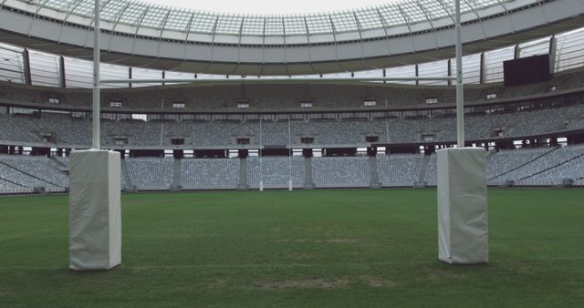 Goal posts on rugby pitch at empty sports stadium with tiered seating, copy space - Download Free Stock Photos Pikwizard.com