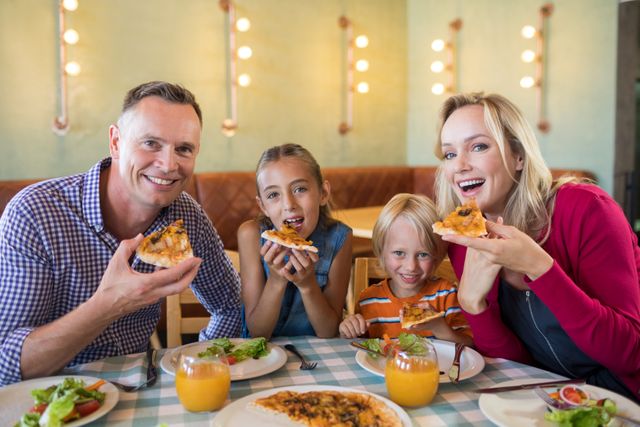 Family enjoying a meal at a restaurant, sharing pizza and smiling. Perfect for advertisements about family dining, restaurant promotions, and articles on family bonding and dining out.