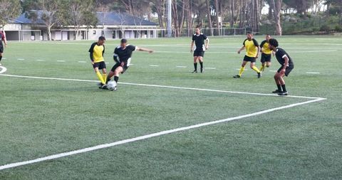 Soccer Players Engaging in Intense Football Match on Field