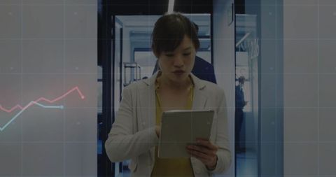 Asian Professional Analyzing Data with Tablet in Modern Office