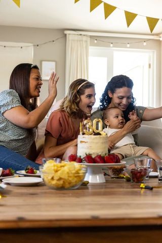 Diverse group of friends celebrating with cake selfie