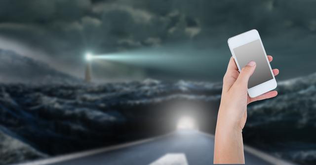 Digital composite image of hand holding smart phone with sea in background - Download Free Stock Photos Pikwizard.com