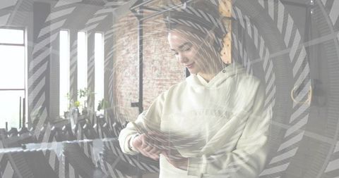 Checking smartwatch in industrial loft — casual woman adjusting watch in morning light