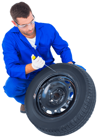 mechanic in blue coveralls kneeling with tire transparent background - Download Free Stock Videos Pikwizard.com