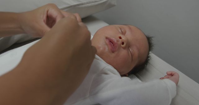 A nurse tends to a newborn baby at the hospital. Gentle care is provided in a serene maternity ward setting.